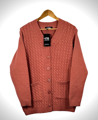 Cozy&Drape terracotta cable knit cardigan sweater with long sleeves, front buttons, and two pockets on a hanger.